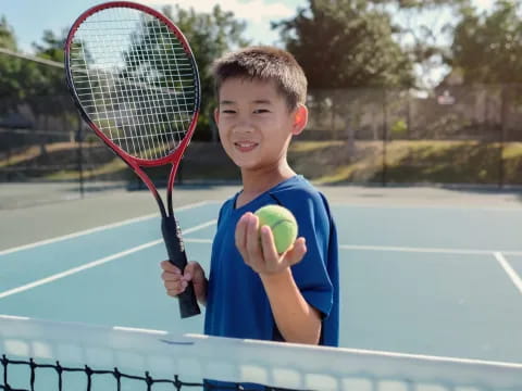 a boy holding a tennis racket