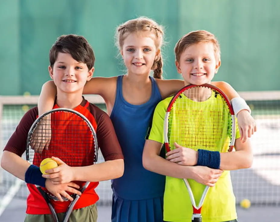 a group of kids holding tennis rackets