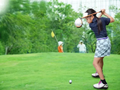 a girl swinging a golf club