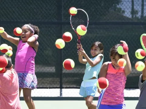 a group of kids playing tennis