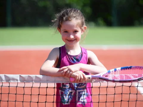 a little girl playing tennis