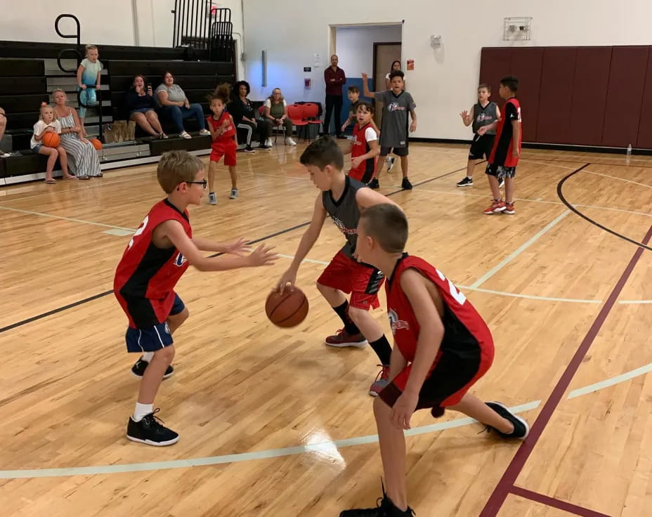 a group of kids playing basketball