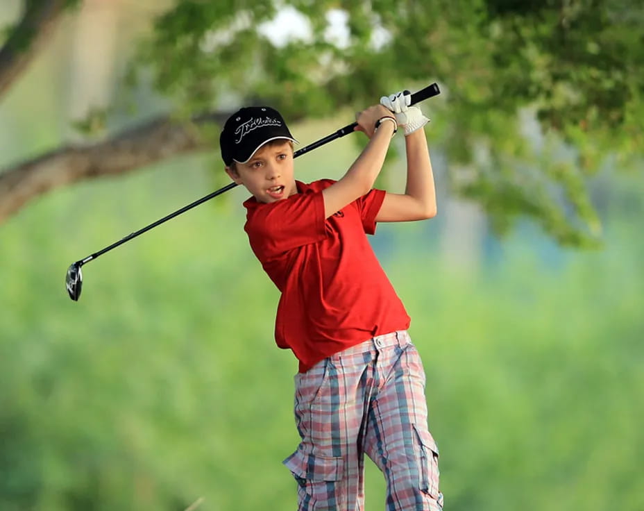 a boy swinging a golf club