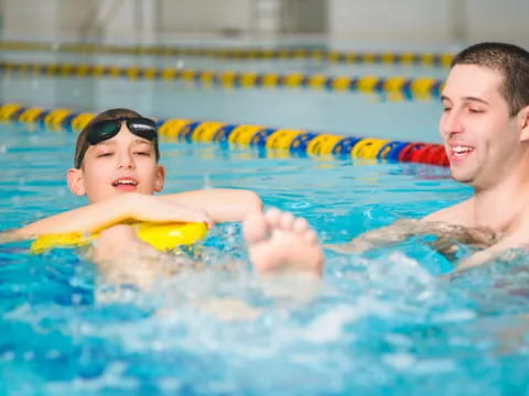 a person and a boy in a pool