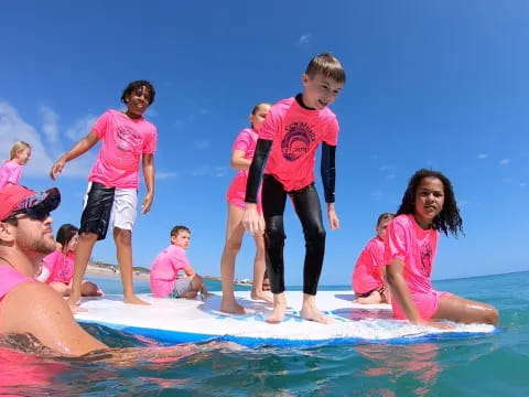 a group of people on a surfboard in the water