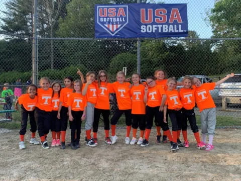 a group of kids in orange shirts