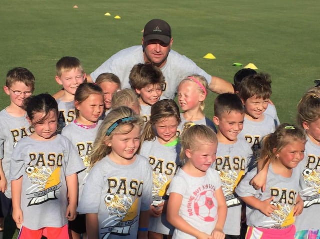 a person standing with a group of kids