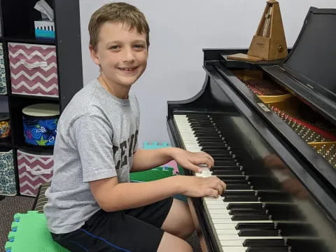a boy sitting at a piano