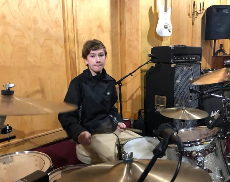 a person sitting on a drum set