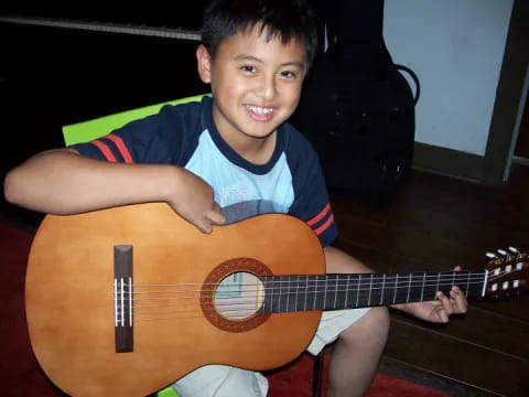 a boy holding a guitar