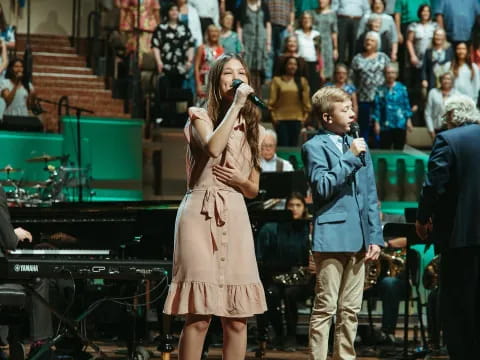 a boy and girl singing on stage