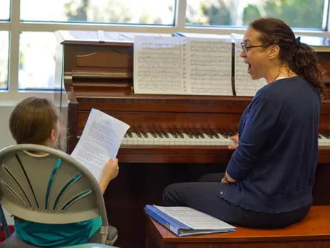 a person and a boy playing piano