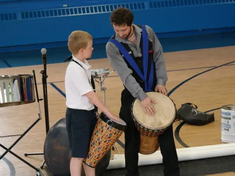 a person and a boy playing drums