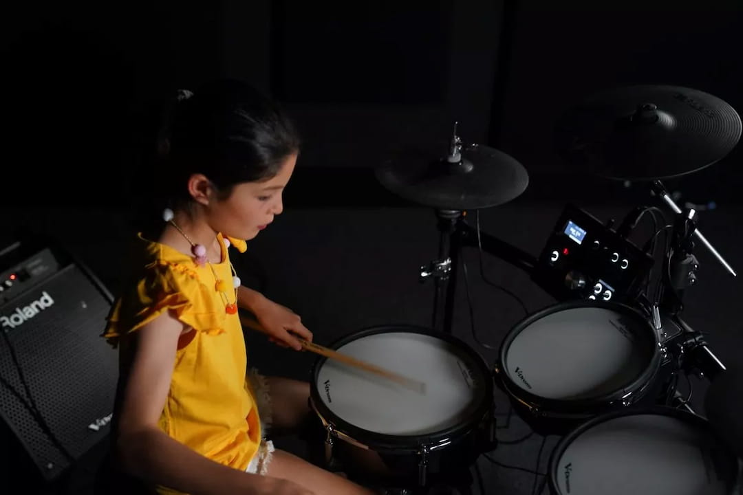 a young girl playing drums