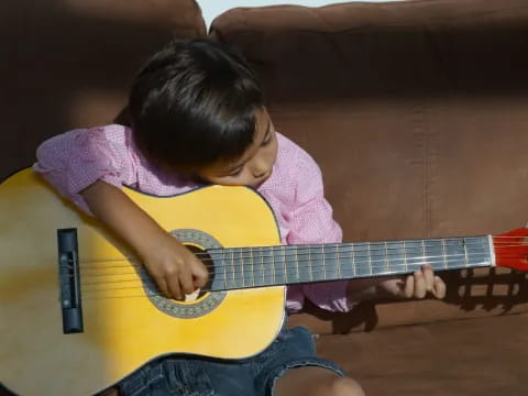 a child playing with a guitar