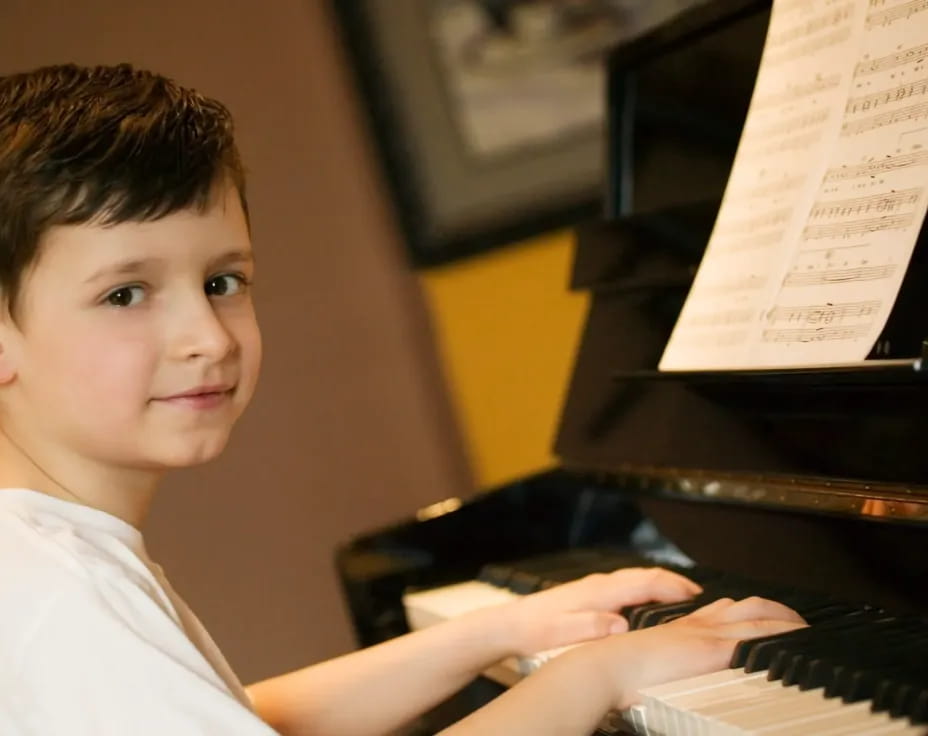 a boy playing a piano