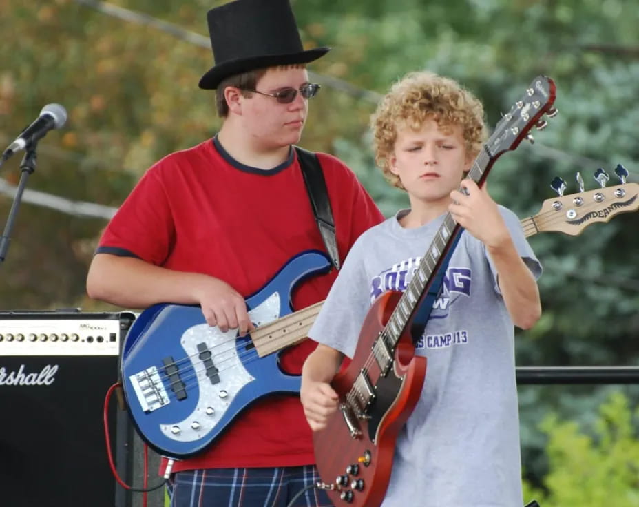 two boys holding musical instruments