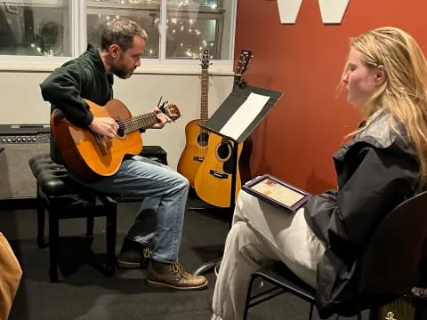 a man and a woman playing guitars