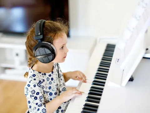a young girl playing a piano