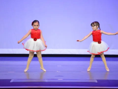 two girls wearing dresses and dancing