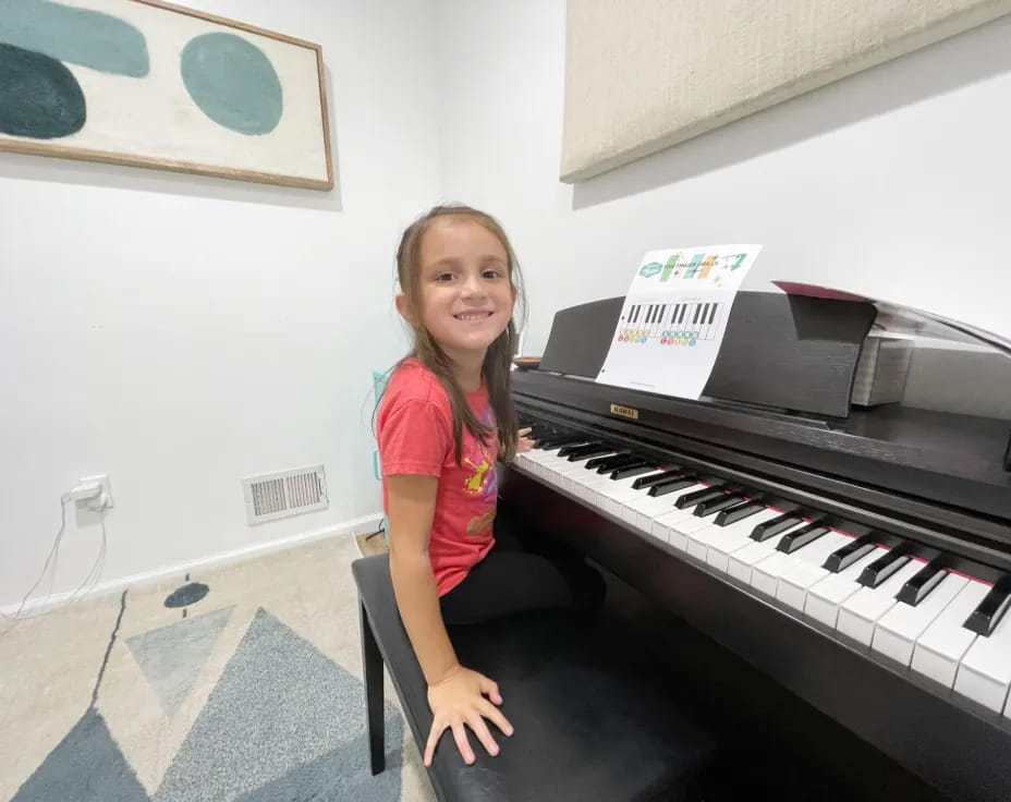 a girl sitting at a piano