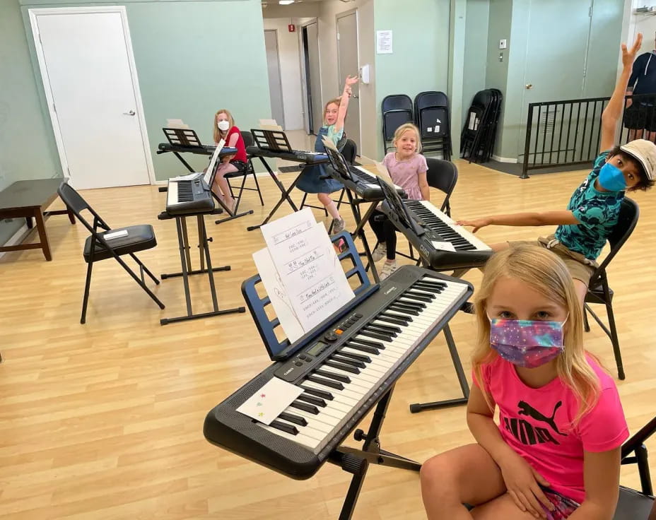 a group of children playing piano
