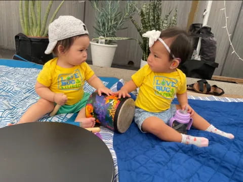 two children sitting on a mat