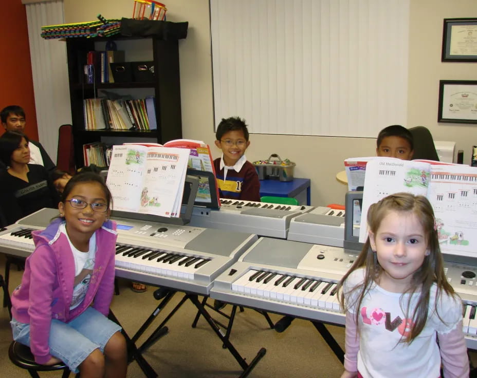 a group of kids sitting at a piano