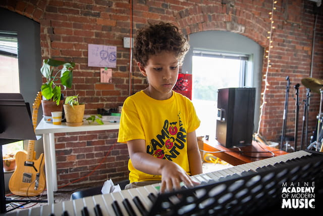 a boy playing a keyboard