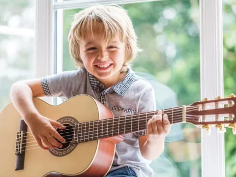 a young boy playing a guitar