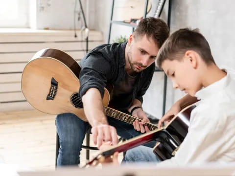 a person playing guitar with a boy