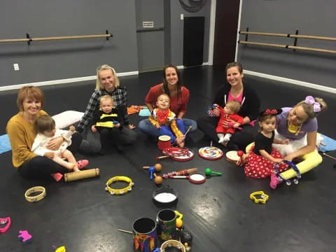 a group of people sitting on the floor with toys