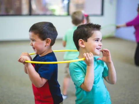 a couple of boys holding a yellow rope