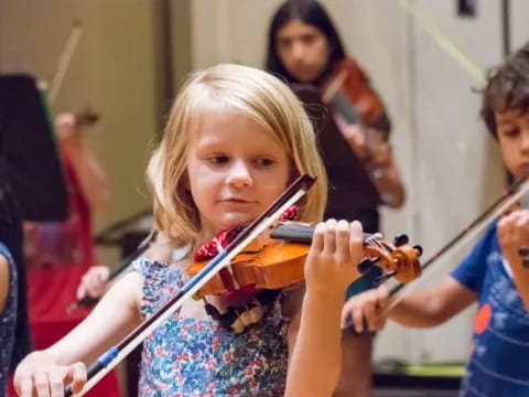 a young girl playing a violin