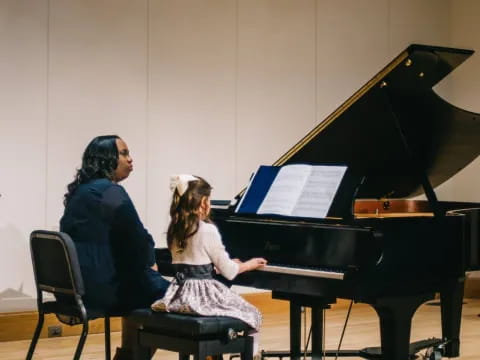 a person and a girl playing piano
