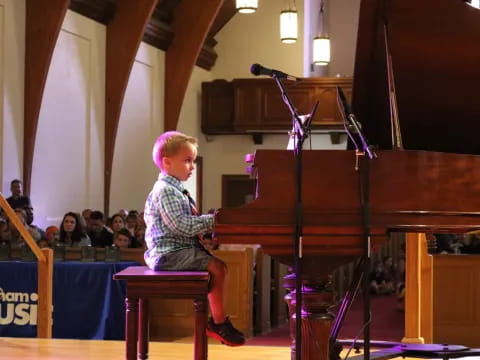 a boy sitting at a piano