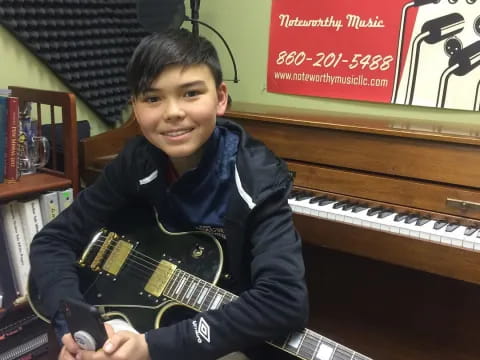 a boy holding a guitar