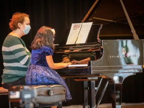 a couple of women playing piano