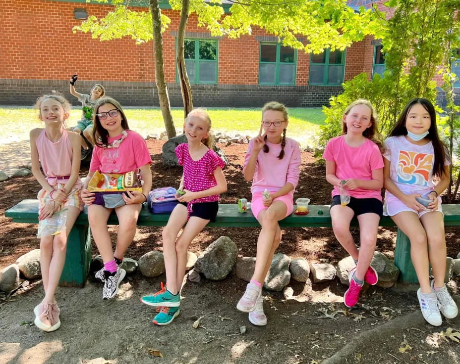 a group of girls sitting on a bench