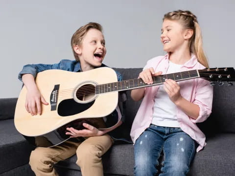 a boy and girl playing guitar
