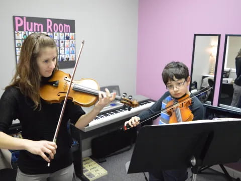 a boy and girl playing the violin