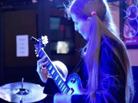 a woman playing a guitar