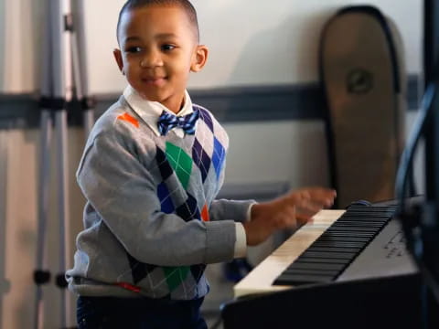 a young boy playing a piano