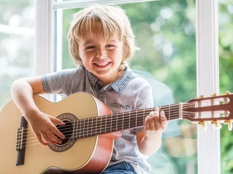 a young girl playing a guitar