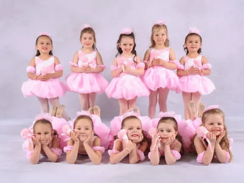 a group of girls in pink dresses