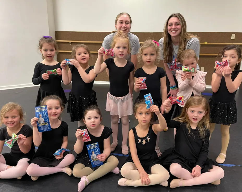 a group of girls holding up cans