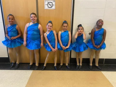 a group of women in blue dresses