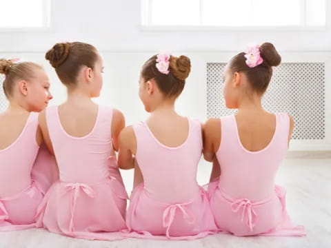 a group of girls in pink dresses