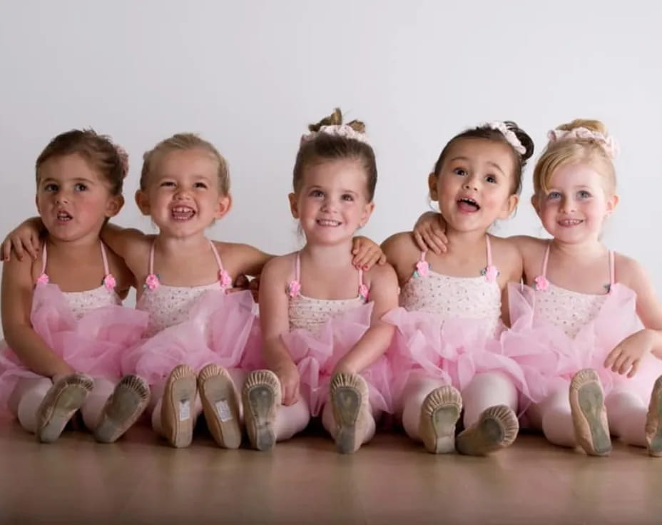 a group of children in pink dresses