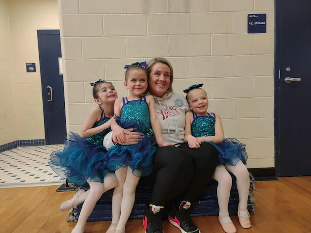 a group of girls sitting on a bench